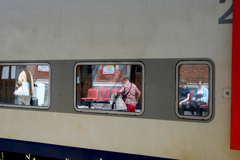 People reflecting on the windows of a train